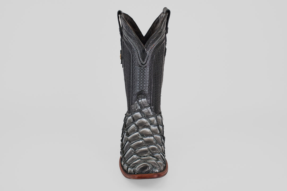 The Conor - Newspaper boot features a black, narrow square toe with a reptile-textured foot, decorative shaft stitching, and a brown sole, shown facing forward against a plain light background.