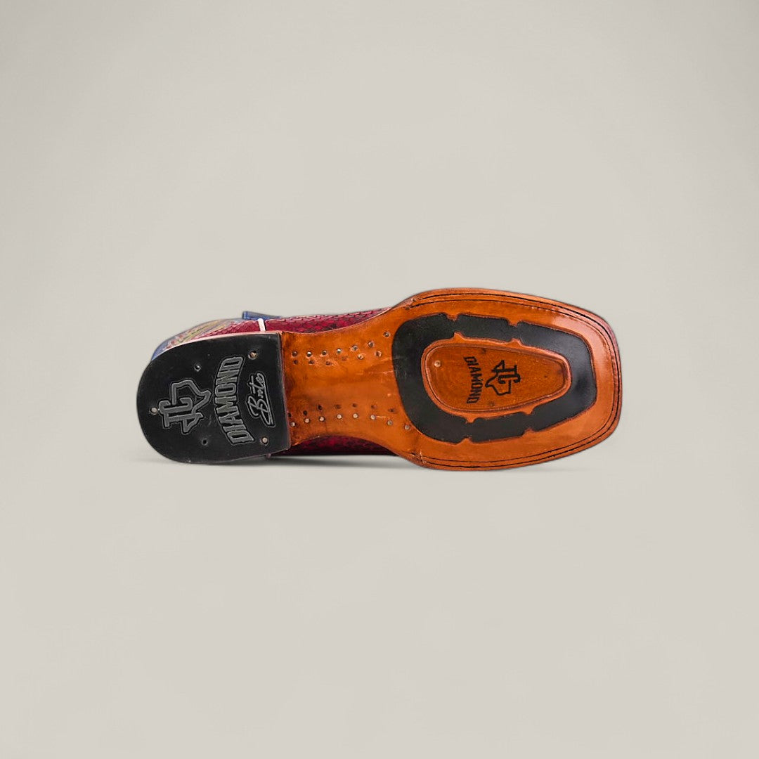 The underside of the Exotic Python - Ruby / Blue - Square Toe boot features decorative stitching, branded logos, and a black rubber heel cap from the Platinum Collection, set against a plain light background.