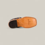 A single Exotic Full Quilt Ostrich Fawn - Square Toe - Kids Boot is shown from the bottom, featuring Western elegance with a tan leather sole, LUCCHESE and star logo, black heel, and visible stitching.