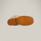 The Orion Suede Bone - Square Toe - Kids Boots feature a tan suede upper with subtle embroidery, a light brown rubber sole with tread patterns, and a slightly raised heel. Shown from the sole for detail.