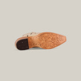 The Tessa Champagne Mid Shaft Snip Toe boot is shown on its side, highlighting its decorative floral-engraved sole and stitched leather heel—ideal for women who value both style and craftsmanship.