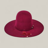 The 4X Burgundy - TC Hats features a wide brim, deep maroon color, domed crown, decorative band, and a Texas-shaped pin on the brim, set against a plain light gray background.