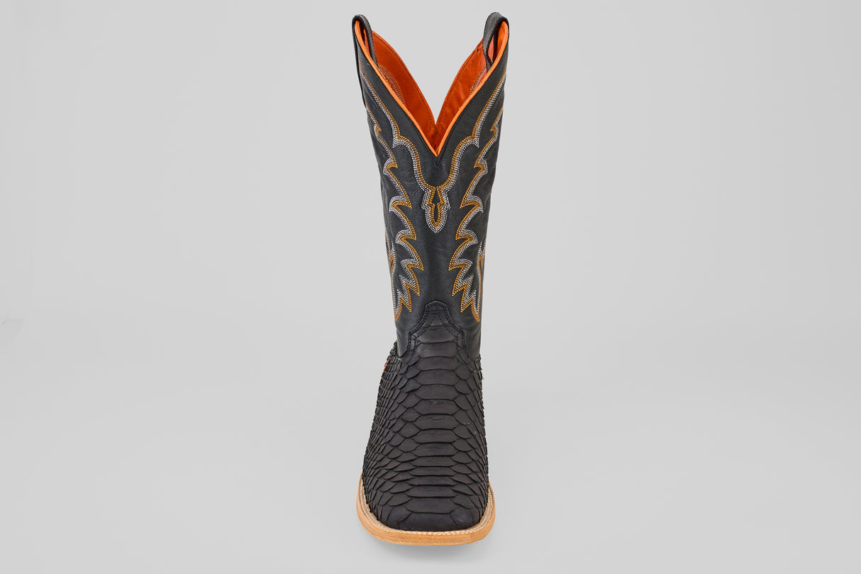 The Wayne - Matte Black - Square Toe boot features a matte black, scaly texture, yellow stitching, and a brown sole. Shown from the front on a plain light gray background.