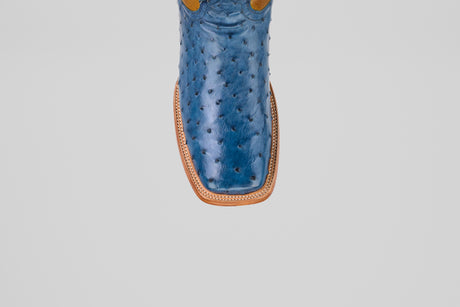 A top view close-up of the Ridge - Blue - Square Toe boot, crafted from blue ostrich leather with a tan welt and square toe, shown on a plain light gray background.