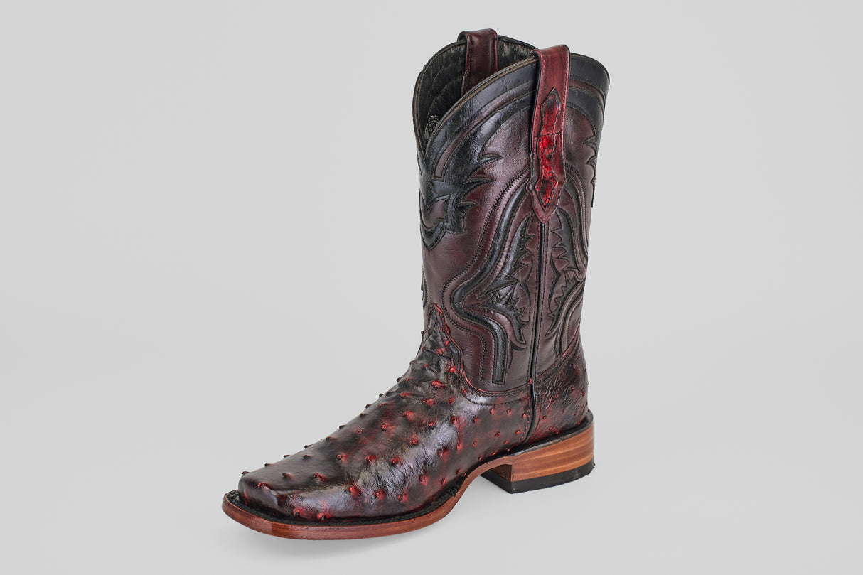 The Exotic Ostrich - Black Cherry - Rodeo Toe boot features decorative stitching, textured ostrich leather in black cherry, and a wooden heel, showcased against a plain light gray background.