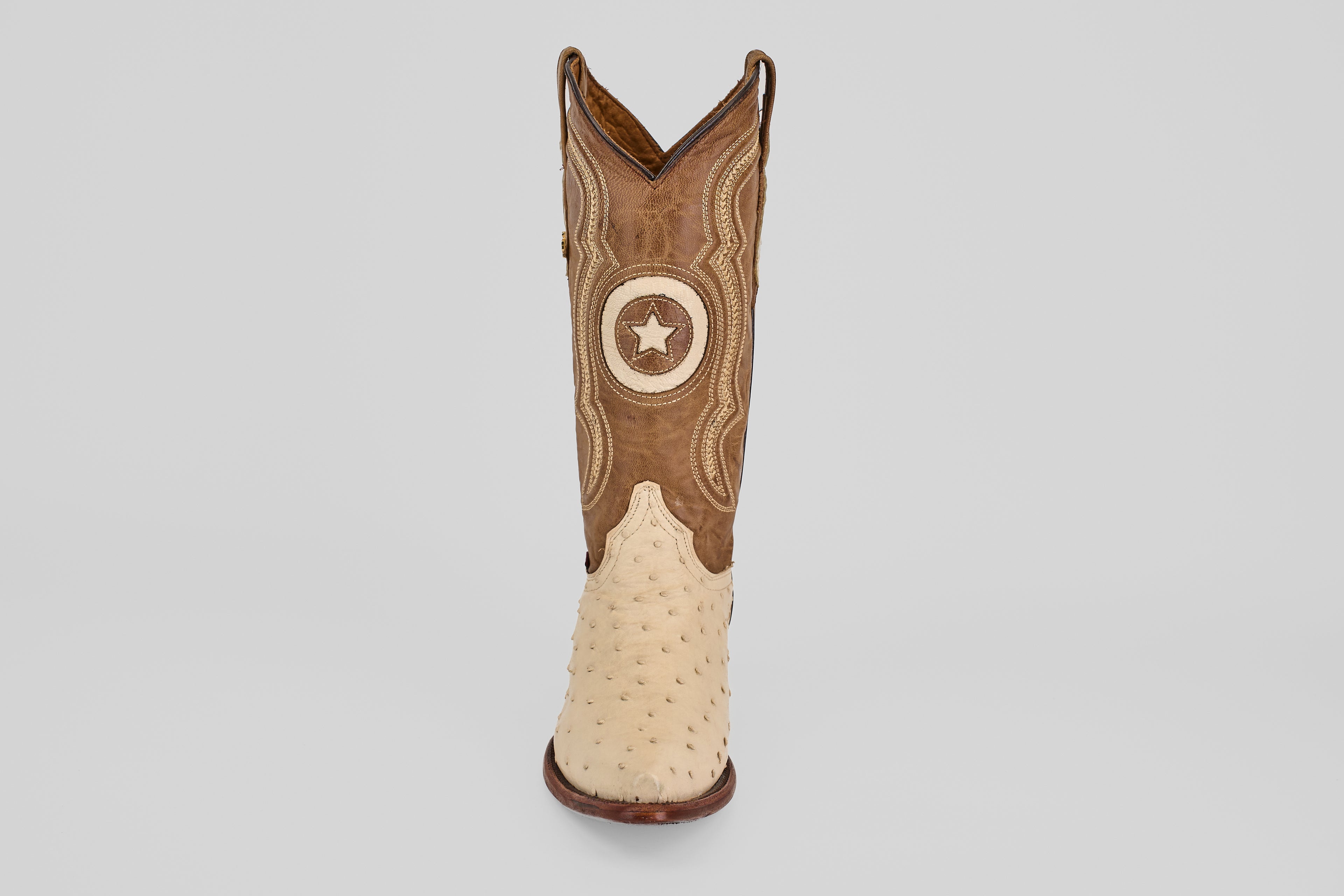The Austin - Bone - Snip Toe cowboy boot features a tan ostrich leather foot, brown upper with decorative stitching, and a circular star patch, shown against a plain white background.