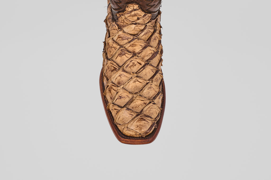 A close-up, top-down view of the toe and front upper part of the Conor - Matte Orix cowboy boot, featuring a narrow square toe and a distinctive textured Pirarucu leather pattern in a tan finish.