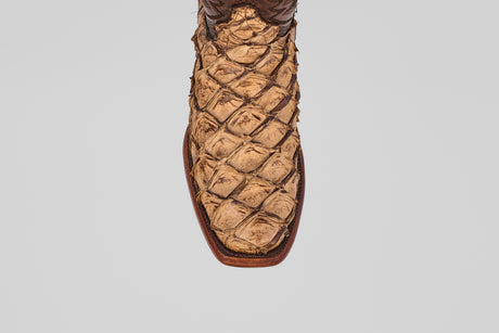 A close-up, top-down view of the toe and front upper part of the Conor - Matte Orix cowboy boot, featuring a narrow square toe and a distinctive textured Pirarucu leather pattern in a tan finish.
