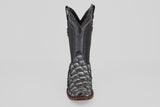 The Conor - Newspaper boot features a black, narrow square toe with a reptile-textured foot, decorative shaft stitching, and a brown sole, shown facing forward against a plain light background.