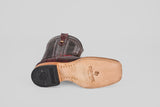 The Ranger – Wine – Square Toe boot rests on its side, revealing a leather sole with the Twisted X logo, tan stitching, a black rubber heel, and an upper of dark brown textured leather with decorative stitching in a classic square toe style.