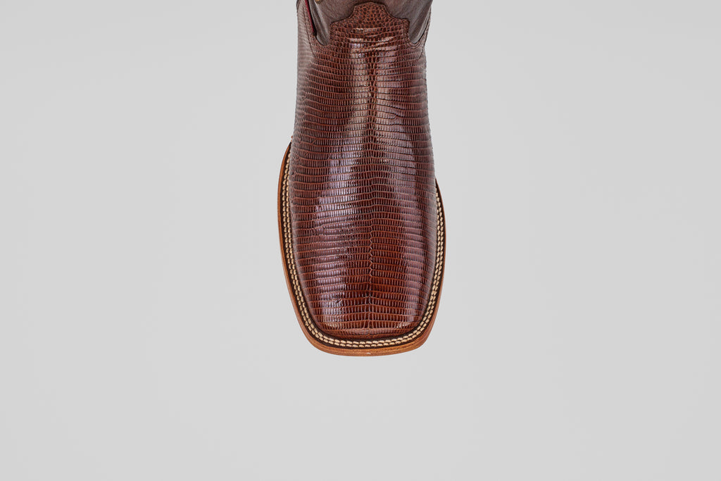 A close-up, top-down view of the toe of the Blaze – Brown – Square Toe boot showcases lizard-textured leather and decorative stitching, highlighting the rugged elegance of this classic western style.