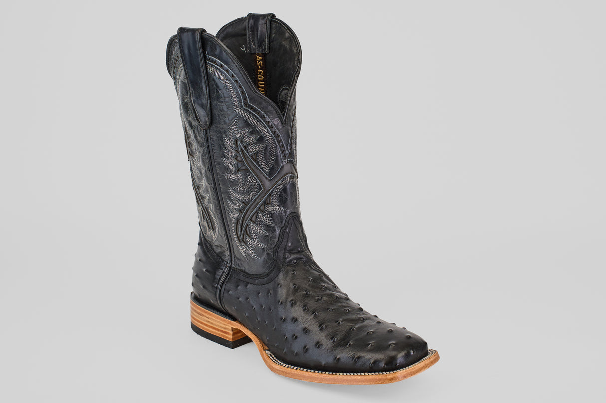 The Ostrich Black - Embossed Leather - Square Toe (E424) boot features detailed stitching, textured leather, a square toe, and a light brown stacked heel and sole, displayed on a plain light gray background.