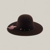 The 10X - Chocolate - TC Hats is a wide-brimmed, dark brown felt Western hat featuring a decorative band and attached tag, shown against a plain light background.