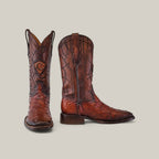 The Moroni Chestnut Ostrich Laser & Embroidery - Square Toe - CU457 cowboy boots, featured on a plain gray background, highlight their square toe design. One boot is upright while the other lies on its side, showcasing intricate detailing along with the heel and sole.
