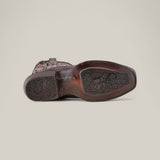 The image displays the sole of the Over Brown Python Laser & Embroidery - Narrow Square Toe - CU401 cowboy boot, made from python leather and showcasing detailed laser engravings with a textured pattern. The worn sole indicates use, and the boot lies horizontally on a plain, light background.