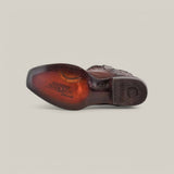 The image shows the underside of a Cuadra Over Chestnut Laser & Embroidery shoe with visible stitching. The sole features engraved text and designs prominently displaying CUADRA TRADICIONAL. Set against a plain, light background, it evokes their iconic Narrow Square Toe style (CU347).